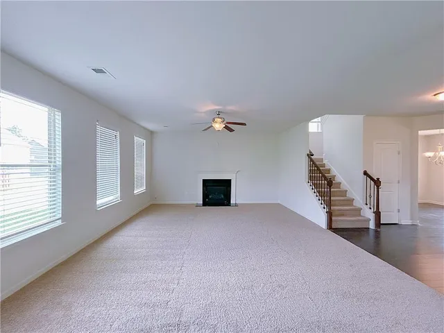 an empty room with windows and fireplace