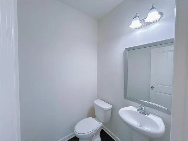 a bathroom with a toilet a sink and mirror