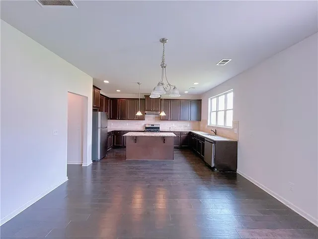 a large kitchen with a lot of counter space and a refrigerator