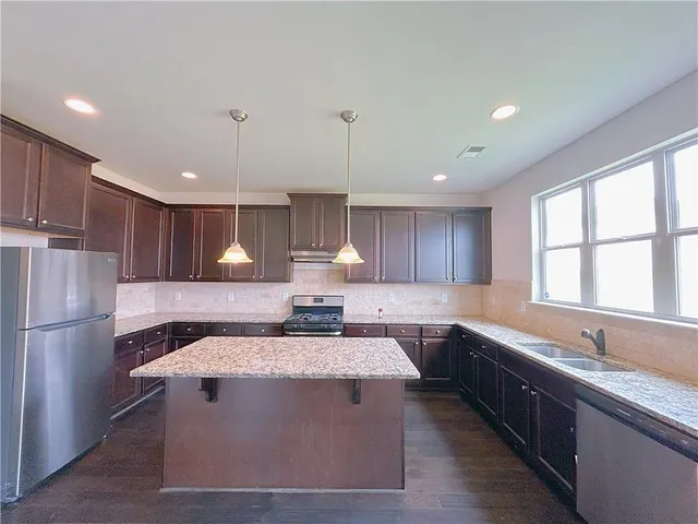 a kitchen with a refrigerator sink and cabinets