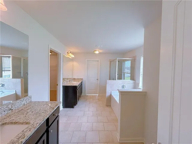 a spacious bathroom with a granite countertop sink and a mirror