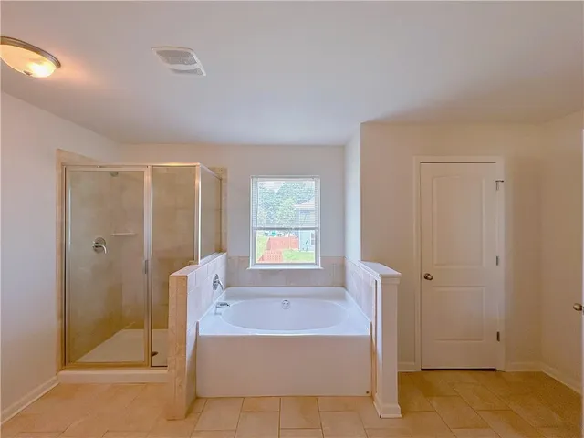 a bathroom with a tub shower and window