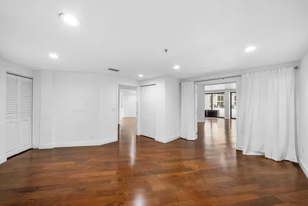 a view of an empty room with wooden floor and a floor to ceiling window