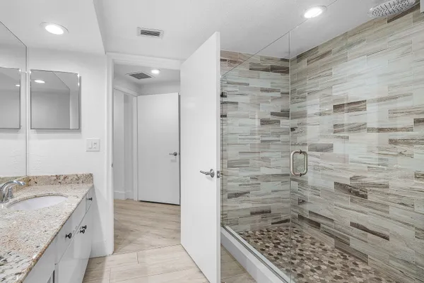 a bathroom with a granite countertop sink a toilet and a mirror