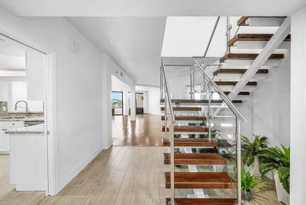 a large kitchen with stainless steel appliances granite countertop a stove top oven a sink and dishwasher a refrigerator with white cabinets