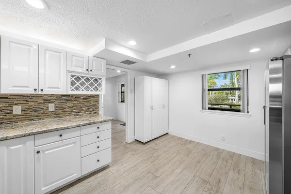 a living room with furniture a flat screen tv and kitchen view