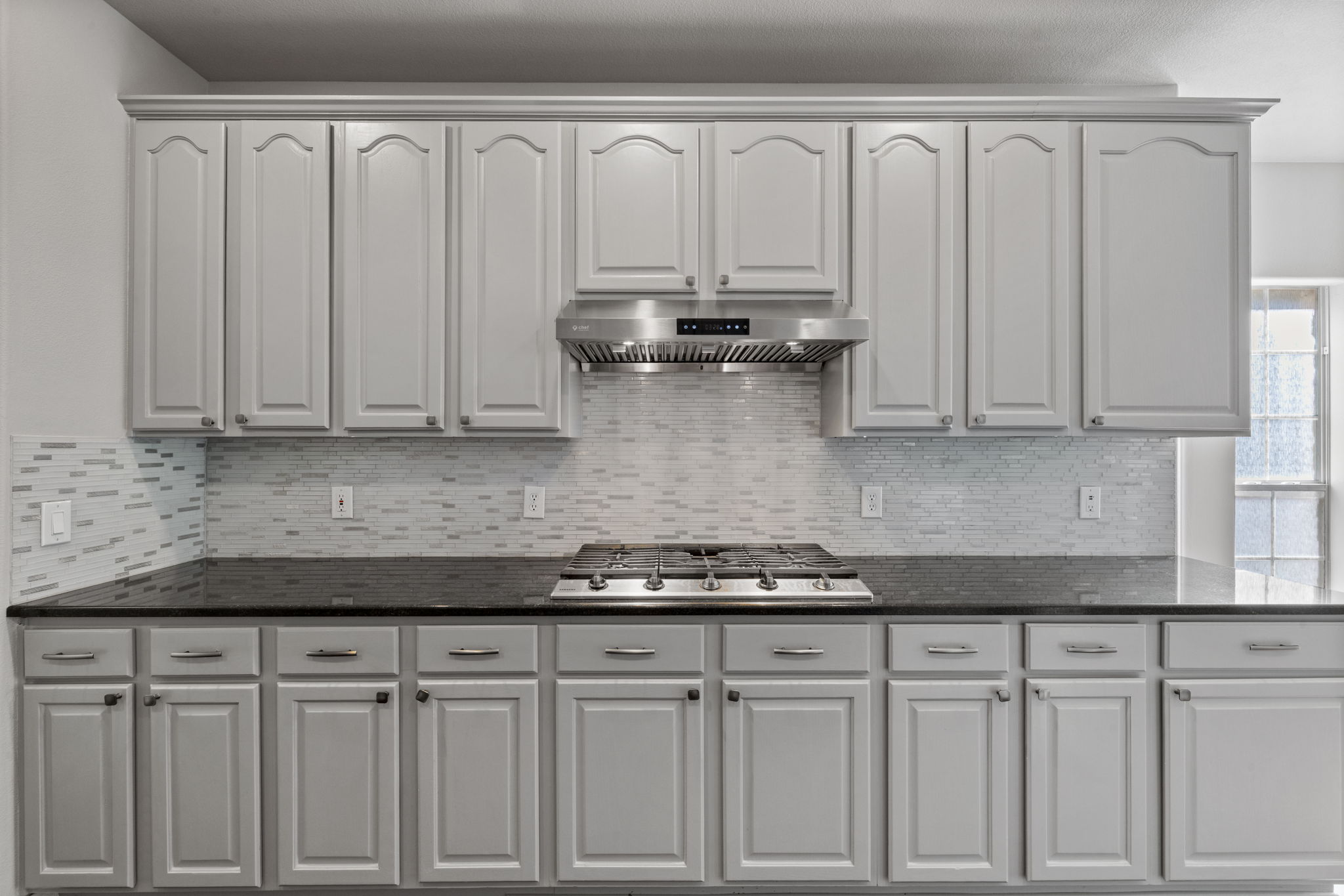 2211 Spring Hollow Path Round Rock, TX 78681 - Photo 9 of 36 Polished stone countertops pair elegantly with a classic tile backsplash and built-in gas range.