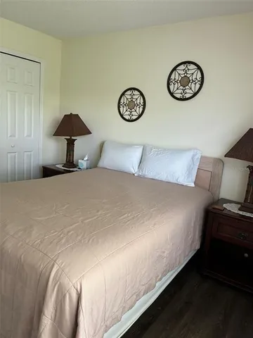 a bedroom with a bed and a lamp on dresser