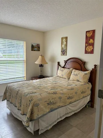 a bedroom with a bed and painting on the wall