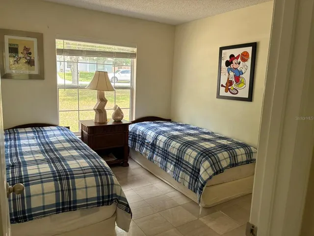 a bedroom with two beds and a large window