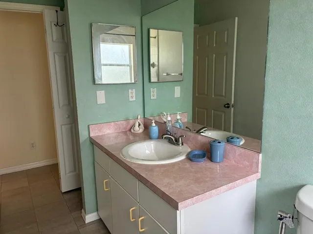 a bathroom with a granite countertop sink a toilet and mirror