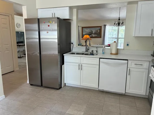 a kitchen with white cabinets stainless steel appliances and a sink