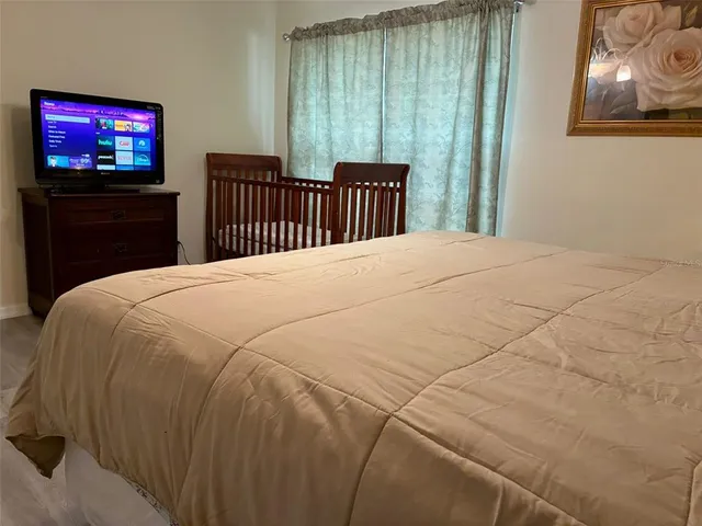 a bedroom with a bed and a flat screen tv