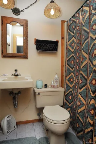 a bathroom with a toilet sink and mirror