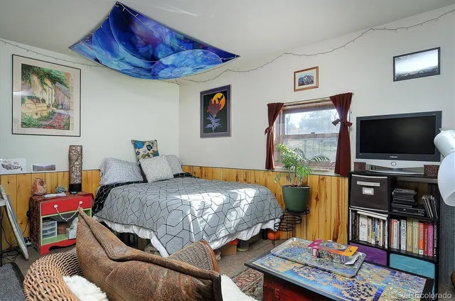 a bedroom with furniture and a flat screen tv