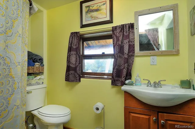 a bathroom with a sink mirror vanity and toilet