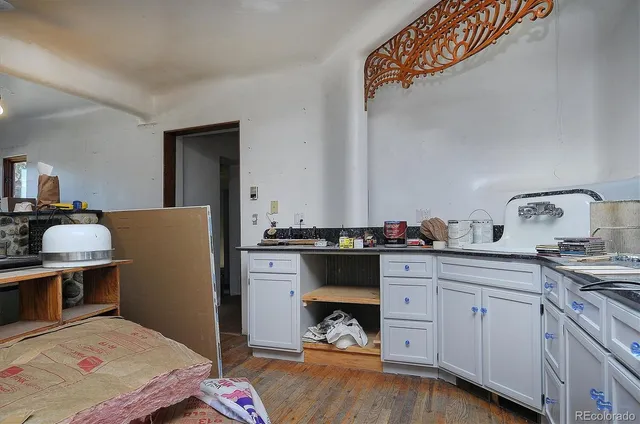 a kitchen with a sink cabinets and wooden floor