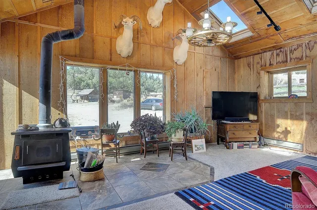 a living room with furniture a flat screen tv and floor to ceiling window