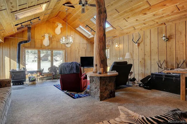 a living room with furniture a large window and a chandelier