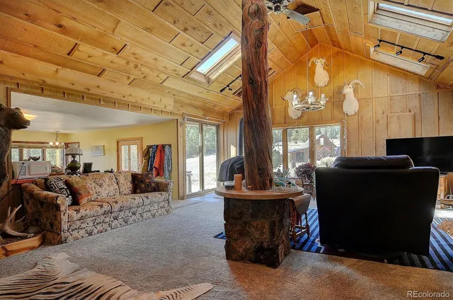 a living room with fireplace furniture and a large window