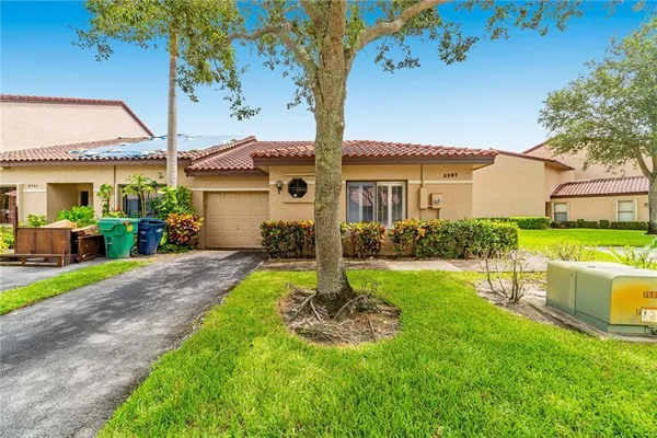 a front view of a house with yard and green space