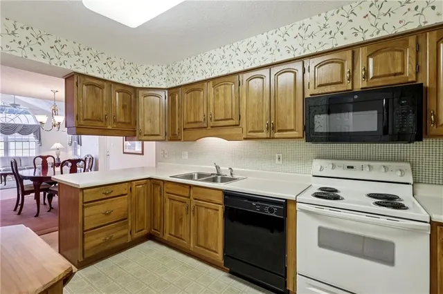a kitchen with stainless steel appliances granite countertop a sink stove microwave and cabinets