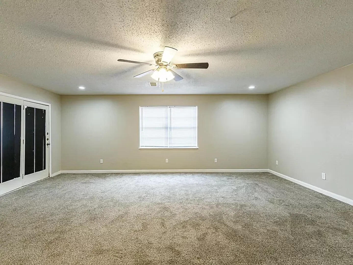 4634 Fordham Street Lubbock, TX 79416 - Photo 11 of 16 an empty room with windows and chandelier fan