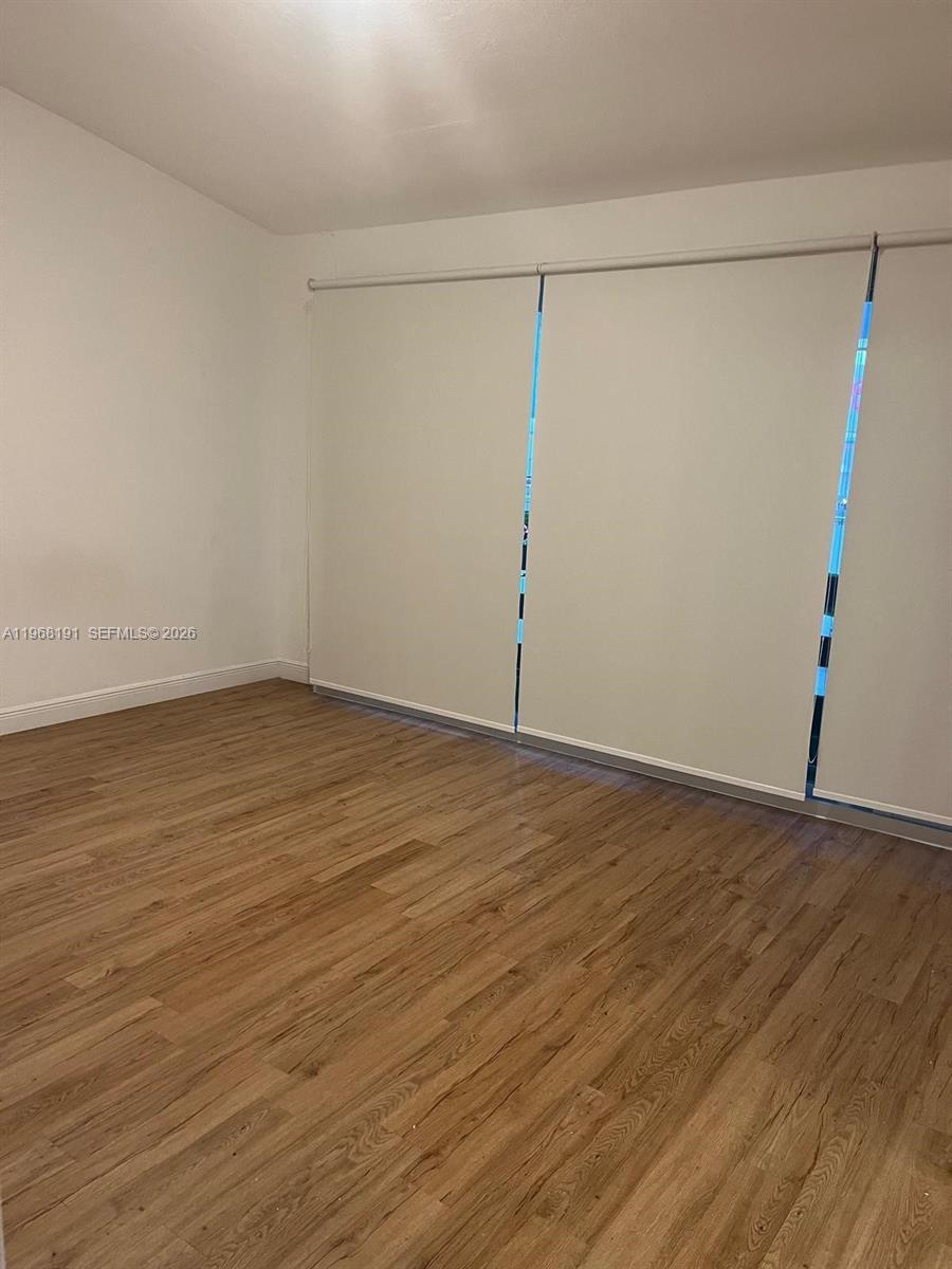 7133 Southwest 109th Court Miami, FL 33173 - Photo 11 of 13 a view of an empty room with wooden floor