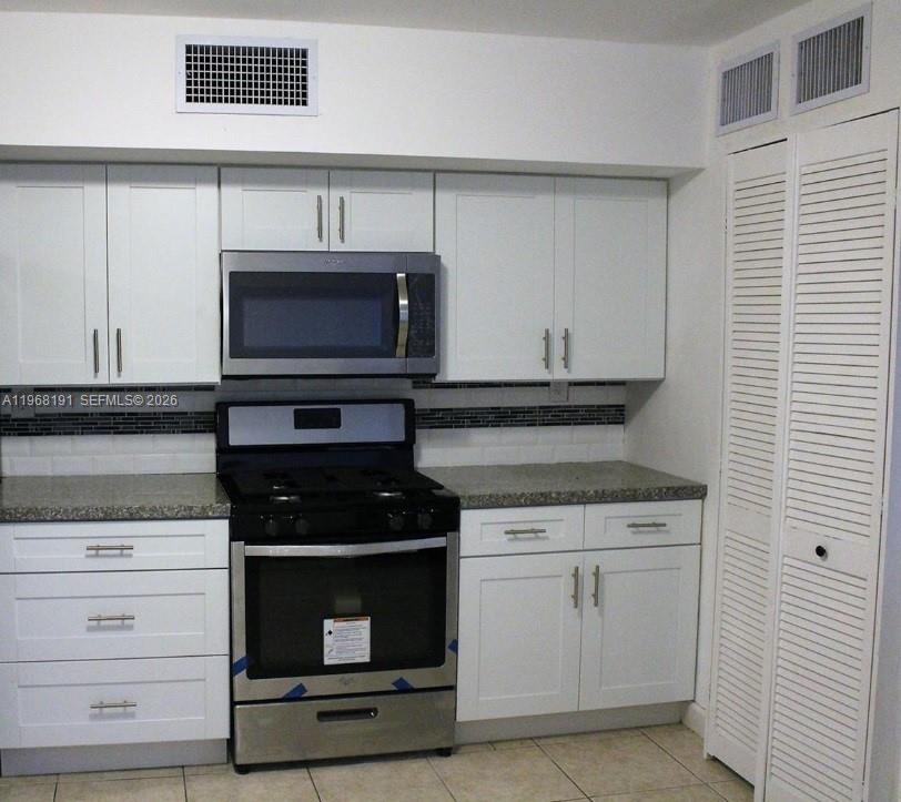 7133 Southwest 109th Court Miami, FL 33173 - Photo 2 of 13 a kitchen with granite countertop white cabinets and stainless steel appliances