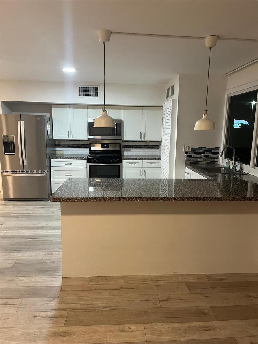 7133 Southwest 109th Court Miami, FL 33173 - Photo 3 of 13 a kitchen with kitchen island a counter top a stove and a refrigerator