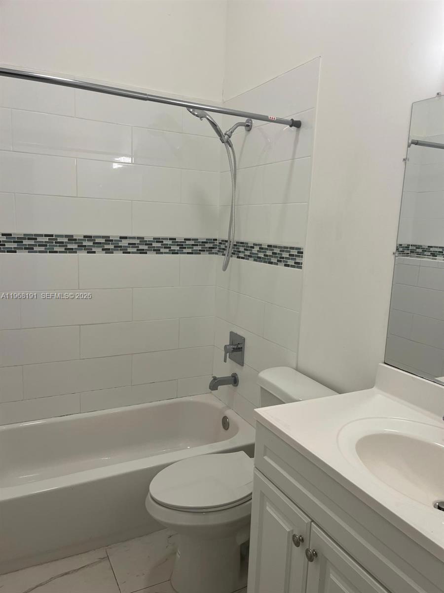 7133 Southwest 109th Court Miami, FL 33173 - Photo 9 of 13 a bathroom with a granite countertop sink mirror vanity and toilet