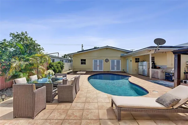 a view of a house with backyard and sitting area