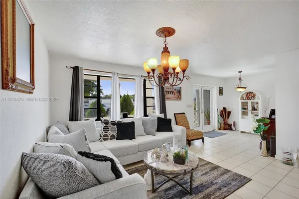 a kitchen with stainless steel appliances a white stove top oven a sink a dining table and chairs