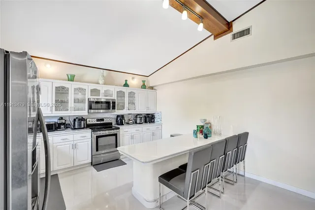 a kitchen with a sink dishwasher stove and cabinets