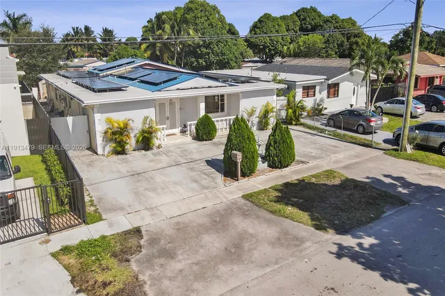 a view of a house with backyard sitting area and swimming pool