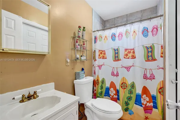 a bathroom with a sink toilet vanity and shower