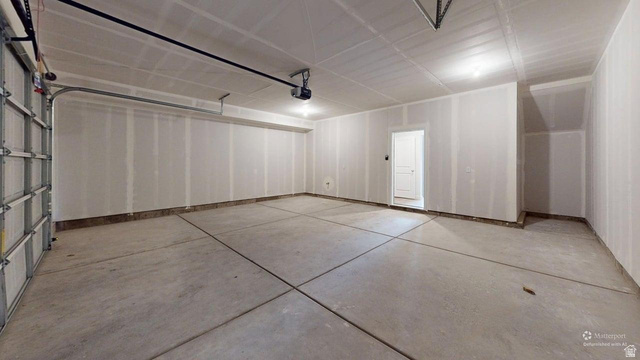777 Pheasantbrook Drive, Unit 2B Centerville, UT 84014 - Photo 40 of 42 Spacious garage with exposed drywall, concrete flooring, and an overhead garage door