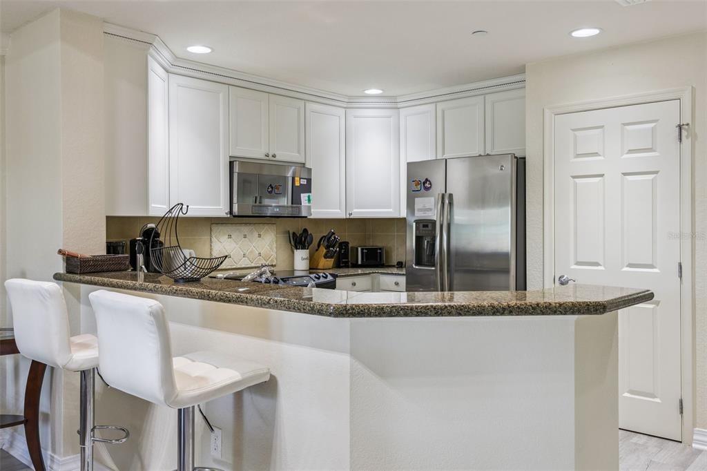 7602 Sandy Ridge Drive, Unit 103 Reunion, FL 34747 - Photo 11 of 61 a kitchen with stainless steel appliances granite countertop a stove a sink a refrigerator and a granite counter tops