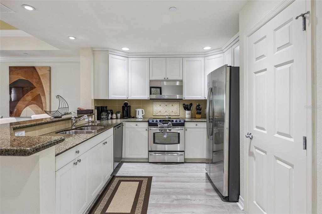 7602 Sandy Ridge Drive, Unit 103 Reunion, FL 34747 - Photo 13 of 61 a kitchen with white cabinets and stainless steel appliances