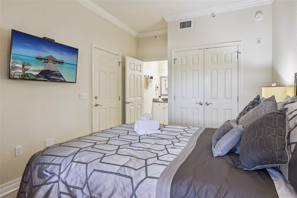 7602 Sandy Ridge Drive, Unit 103 Reunion, FL 34747 - Photo 18 of 61 a bedroom with a bed and a painting on the wall