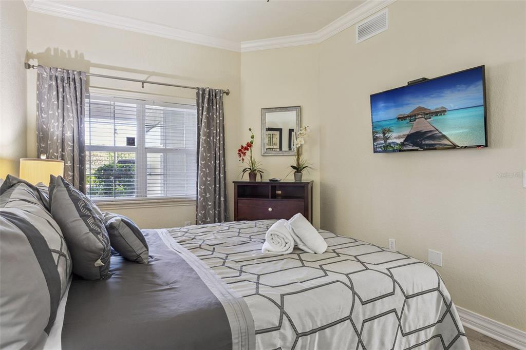 7602 Sandy Ridge Drive, Unit 103 Reunion, FL 34747 - Photo 19 of 61 a bedroom with a bed and a painting on the wall
