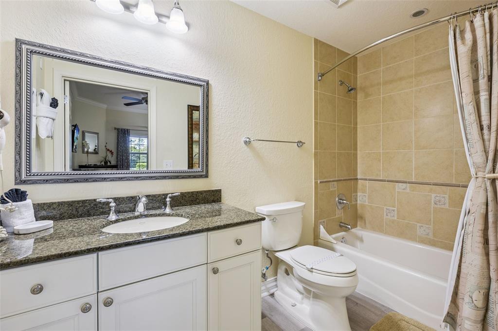 7602 Sandy Ridge Drive, Unit 103 Reunion, FL 34747 - Photo 21 of 61 a bathroom with a granite countertop toilet a sink and a mirror