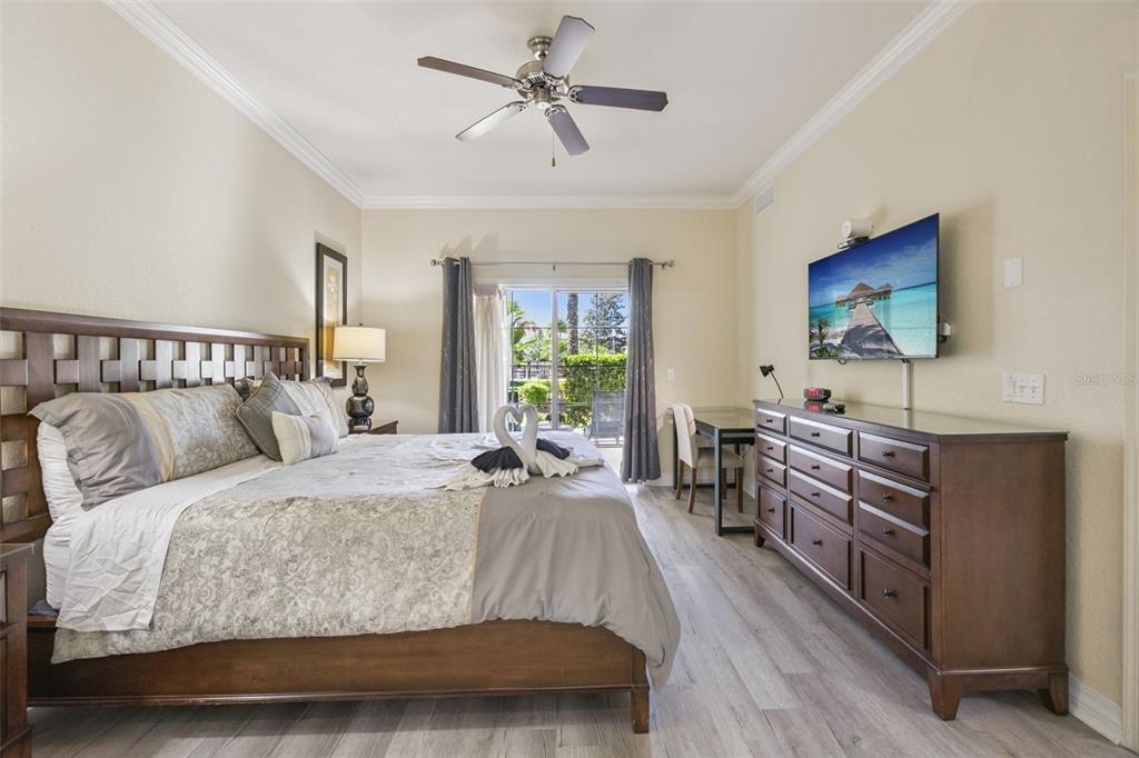 7602 Sandy Ridge Drive, Unit 103 Reunion, FL 34747 - Photo 24 of 61 a bedroom with a bed and a flat screen tv
