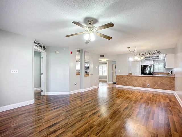 a view of a livingroom with wooden floor and a ceiling fan