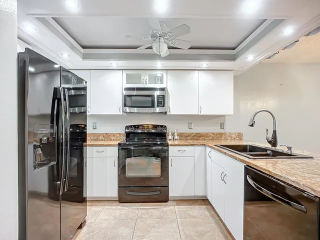 a kitchen with stainless steel appliances granite countertop a stove microwave and cabinets