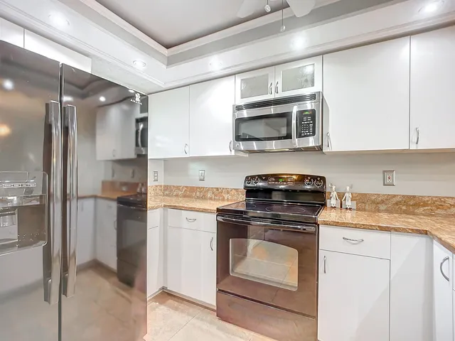 a view of a living room a kitchen island wooden floor and a window