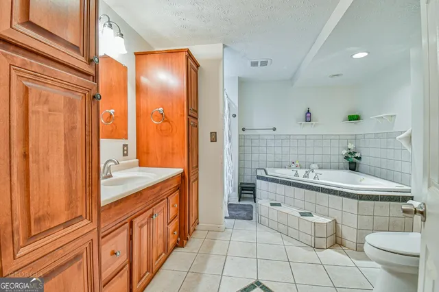 a spacious bathroom with a granite countertop sink toilet and shower