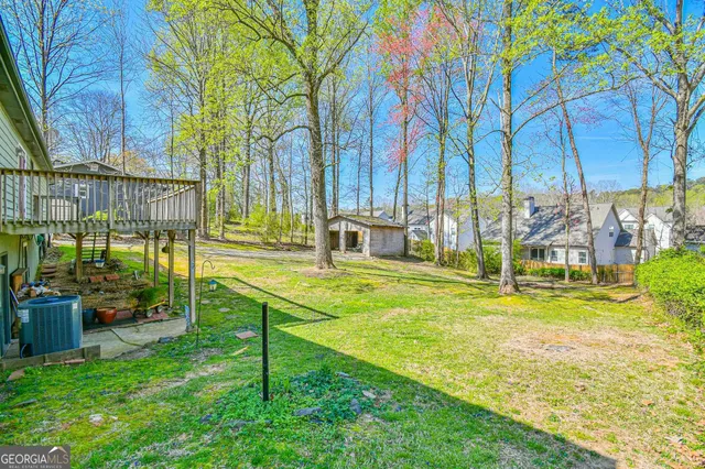 a view of swimming pool with lawn chairs and large trees