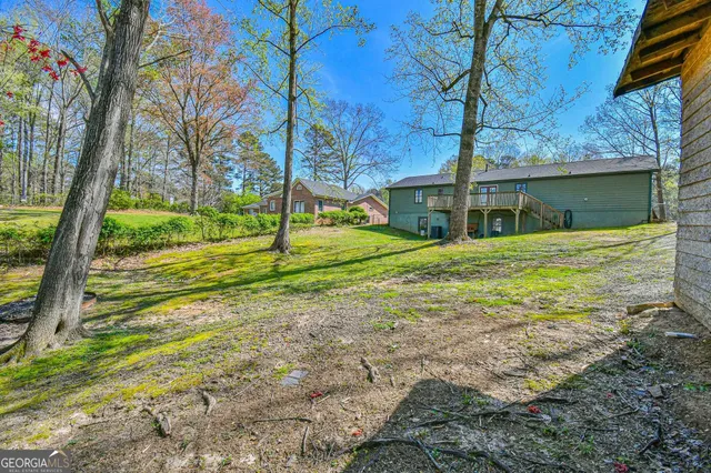 a view of a house with backyard and trees