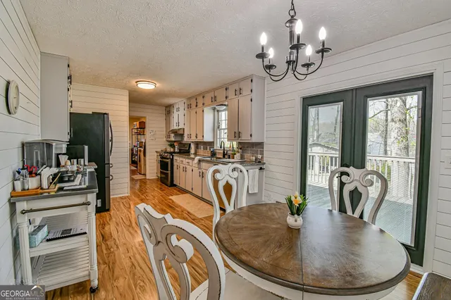 a view of a dining room with furniture a chandelier and wooden floor